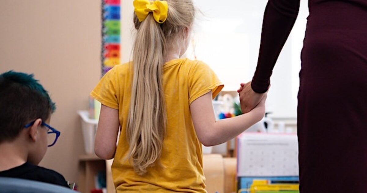 School accused of pushing ‘gender transitions’ in secret, gets sued children girls holding hands teachers school blonde hair bows ribbon classroom backside 1200x630 1