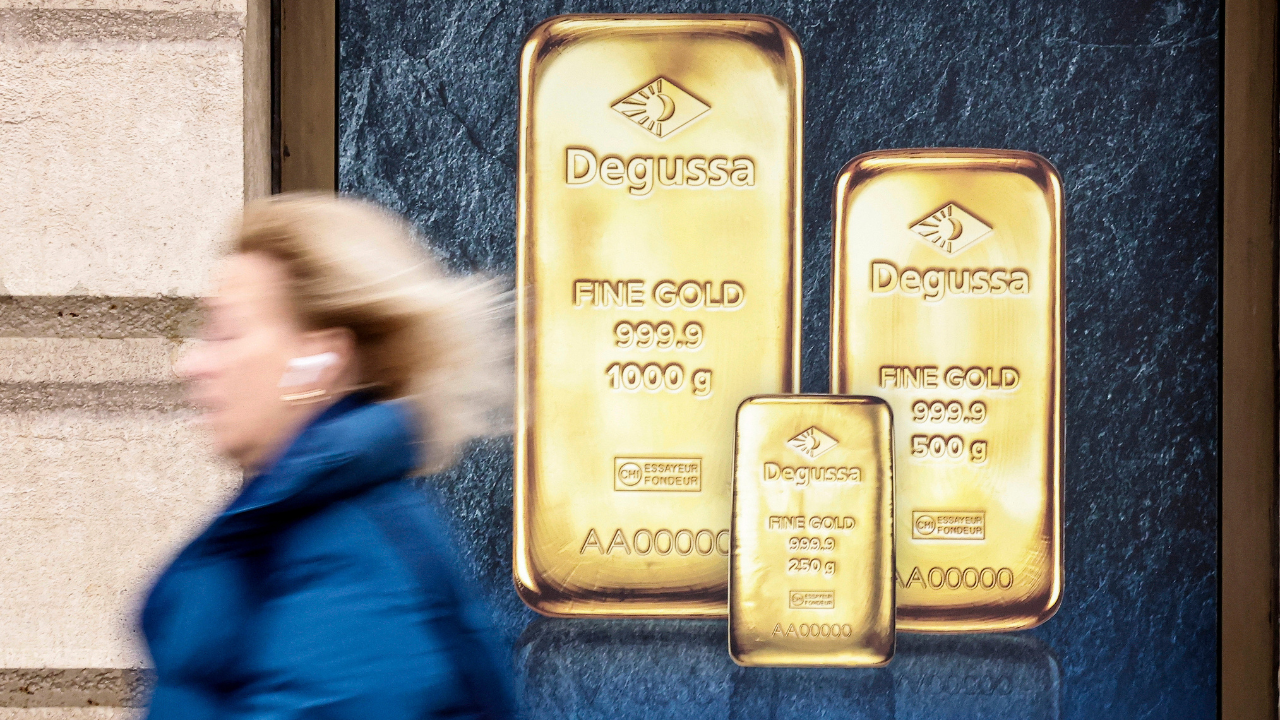 A surprising industry is fueling a new rush for gold — and it’s not slowing down 3294a34b woman walking gold bars